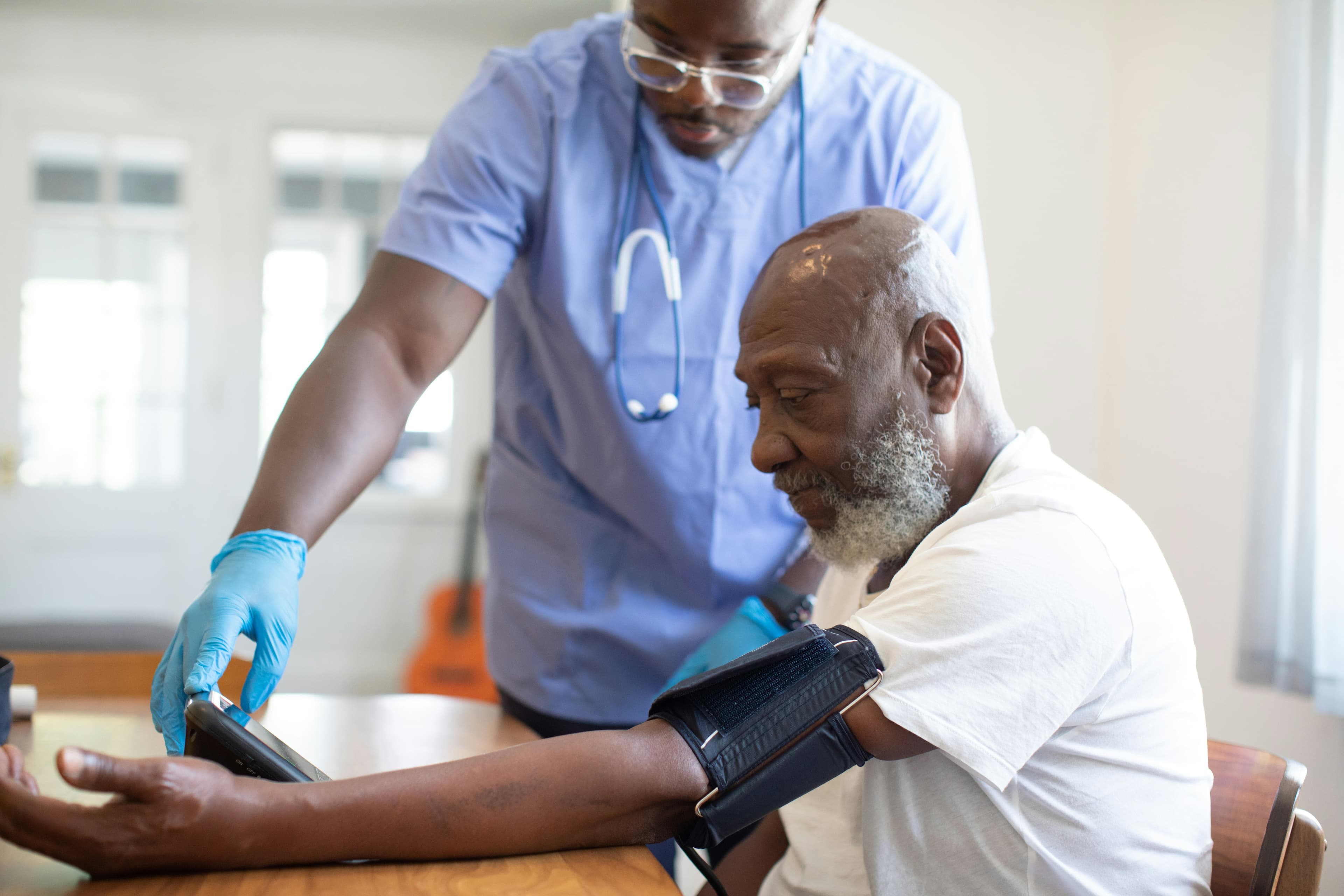 Clinician checking an older adults blood pressure