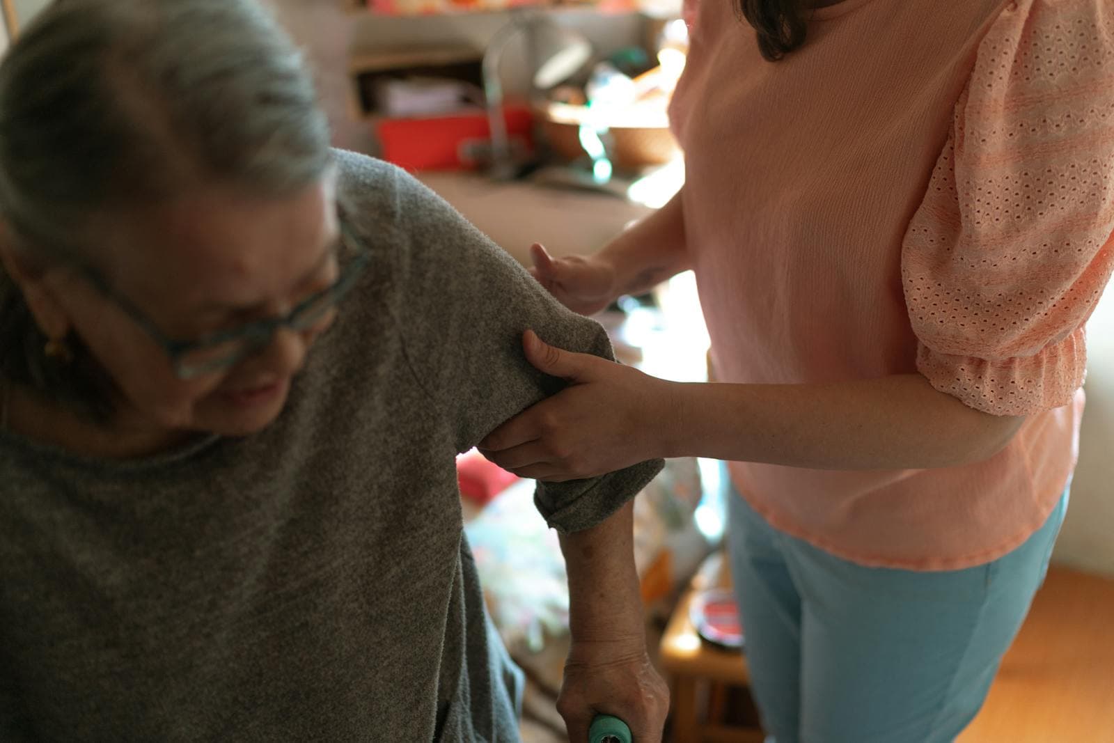 Caregiver assisting an adult participant during an in-home support visit