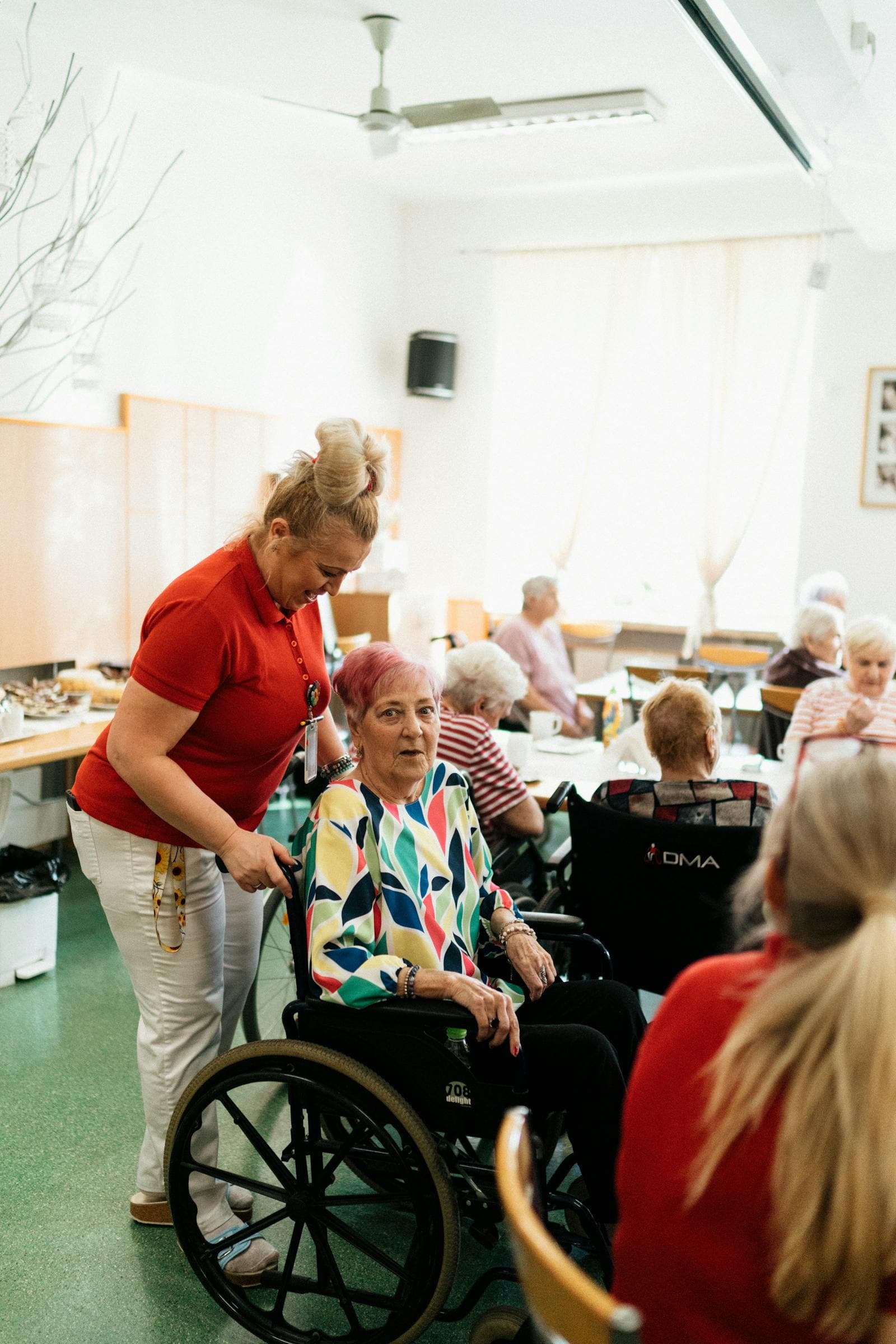 Caregiver helping an adult participant with safe mobility and transfer support